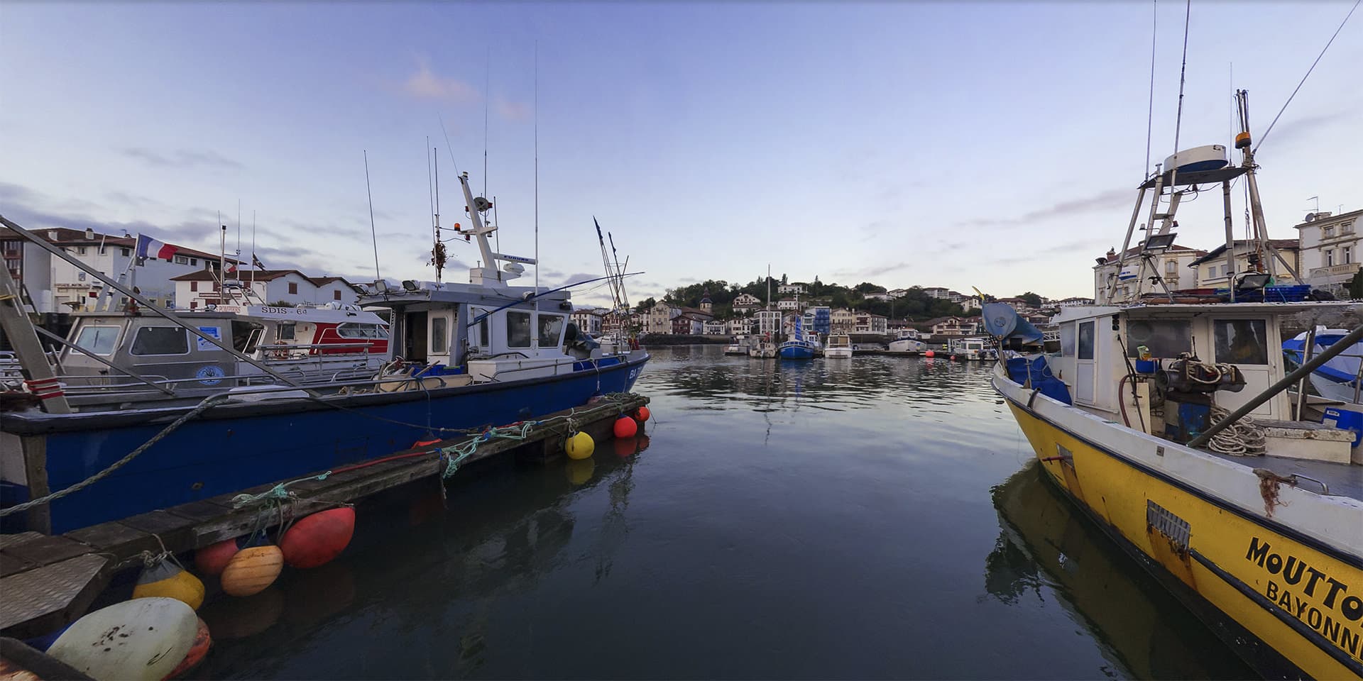 Port de pêche de Saint-Jean-de-Luz avec bateaux traditionnels et quais colorés dans une visite virtuelle immersive